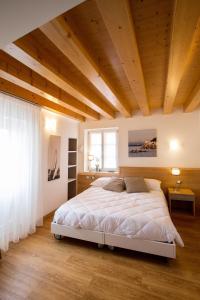 a bedroom with a large bed and a wooden ceiling at Hotel All'Arco in Trieste