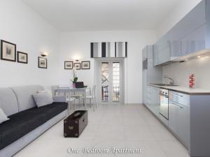 um apartamento branco com uma cama e uma cozinha em Donna Caterina em Sorrento