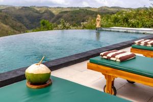 a melon sitting on a table next to a swimming pool at Green Coco Suite by AGATA in Nusa Penida +37 photos