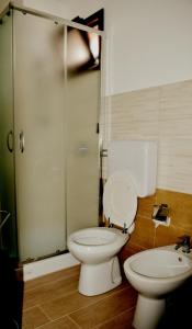 a bathroom with a toilet and a glass shower at B&B Federico II in San Cipirello