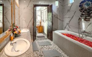 a bathroom with two sinks and a bathtub and a tubermott at The Palms Canggu in Canggu +30 photos