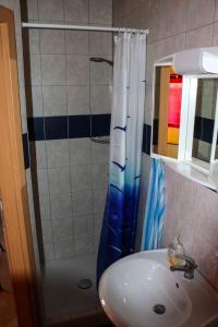 a bathroom with a sink and a shower at Počitniška hiška pod Hadikom in Lendava