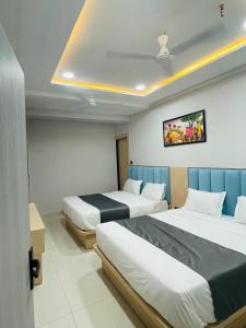 a hotel room with two beds and a tv at Hotel hills in Ahmedabad