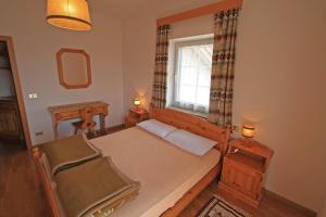 a small bedroom with a bed and a window at Tony Sport appartamenti in Vigo di Fassa +1 photo