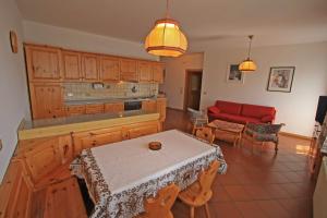 a living room with a table and a red couch at Tony Sport appartamenti in Vigo di Fassa