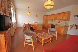 a living room with a table and chairs and a kitchen at Tony Sport appartamenti in Vigo di Fassa