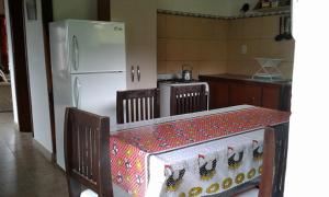 una cucina con un tavolo e un frigorifero bianco di La Protegida a El Chalten Altre 9 foto