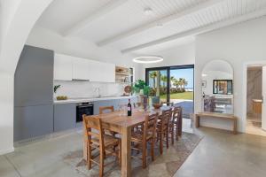 a kitchen and dining room with a wooden table and chairs at The Palms Seaside - Kolymvari in Kolymvari +36 photos