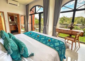 a bedroom with a bed and a desk and a window at The Palms Canggu in Canggu