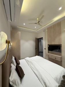a bedroom with a white bed with a tv on the wall at Hotel sky inn in Jalandhar