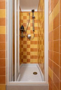 a shower in a bathroom with orange tiles at Bella Vita Stays Relax in Sondrio +14 photos