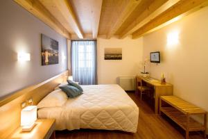 a bedroom with a bed and a desk in it at Hotel All'Arco in Trieste