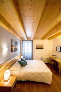 a bedroom with a large bed and a wooden ceiling at Hotel All'Arco in Trieste