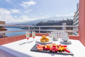 a table with a plate of food and glasses of champagne at Checkin Concordia Playa in Puerto de la Cruz