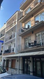 an apartment building with chairs on the balconies at Pensió Anna in Tossa de Mar