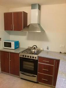 a kitchen with a stove and a microwave at Bahiaxdia Fitz Roy 140 in Bahía Blanca