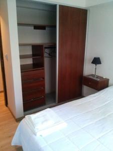 a bedroom with a bed and a dresser and a mirror at Bahiaxdia Fitz Roy 140 in Bahía Blanca