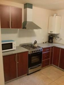 a kitchen with a stove and a microwave at Bahiaxdia Fitz Roy 140 in Bahía Blanca +5 photos