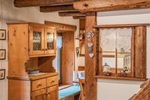 a kitchen with wooden cabinets and a window at Da La Auri in Canale dʼAgordo