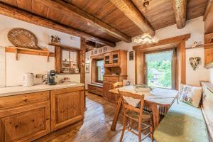 a kitchen with wooden cabinets and a table and chairs at Da La Auri in Canale dʼAgordo