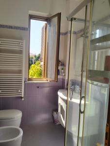a bathroom with a toilet and a sink and a window at terrazza sul castello in Roccella Ionica +3 photos