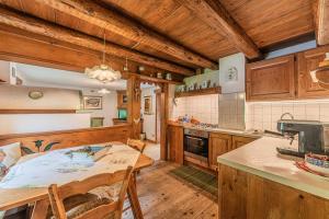 a kitchen with wooden cabinets and a table with chairs at Da La Auri in Canale dʼAgordo +27 photos