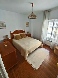a bedroom with a bed and a wooden floor at Apartamento Pena Furada in Ribadeo +14 photos