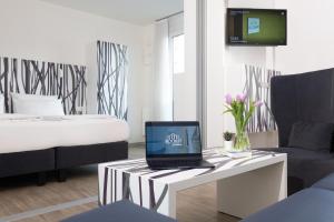 a room with a bed and a laptop on a table at east Apart in Erlangen