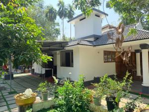 a house with a lot of plants in front of it at Winter Heaven in Cochin
