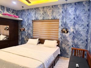 a bedroom with two beds and a blue wall at Winter Heaven in Cochin
