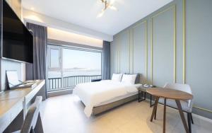 a bedroom with a bed and a table and a television at Dangjin Dubai Hotel in Dangjin