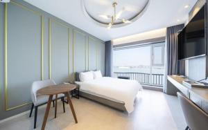 a hotel room with a bed and a table and a desk at Dangjin Dubai Hotel in Dangjin +19 photos