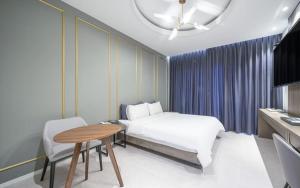 a bedroom with a bed and a table and a desk at Dangjin Dubai Hotel in Dangjin