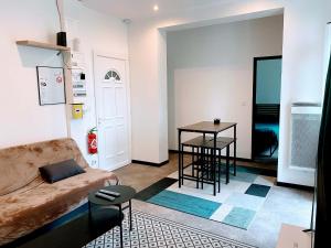 a living room with a couch and a table at LA PERLE RARE centre ville avec internet 4 pers Confort & Emplacement Idéal in Marmande +10 photos