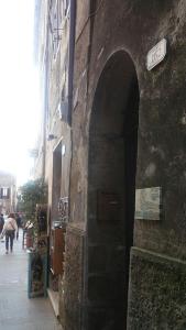 un callejón con un arco en un edificio de piedra en 4 Assi, en Pitigliano