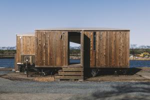 a small wooden building with a door and a table at Earthboat Saitama Kawajima in Kawagoe