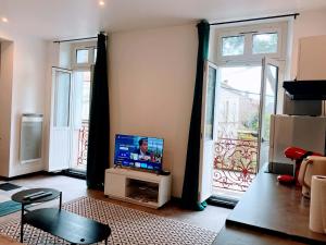 a living room with a tv and a large window at LA PERLE RARE centre ville avec internet 4 pers Confort & Emplacement Idéal in Marmande