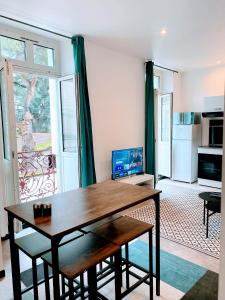 a living room with a wooden table and a kitchen at LA PERLE RARE centre ville avec internet 4 pers Confort & Emplacement Idéal in Marmande