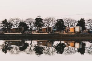 a group of tents next to a body of water at Earthboat Saitama Kawajima in Kawagoe