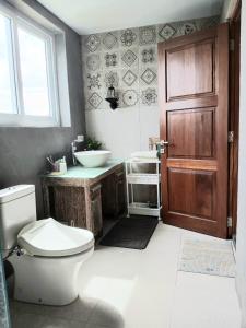 a bathroom with a toilet and a sink and a door at De'Rein Beach House in Sanur +39 photos