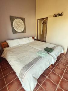 a bedroom with a large bed with white sheets at Casa Presente Guesthouse in Carrapateira