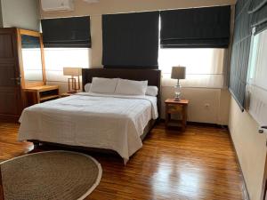 a bedroom with a large bed and two windows at De'Rein Beach House in Sanur