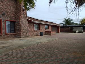 a brick house with a brick driveway in front of it at Colchester Suites - Travel Addo Group in Cannonvale
