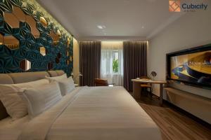 a hotel room with a large bed and a flat screen tv at Cubicity Hoang Dieu in Ho Chi Minh City