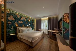 a hotel room with a bed and a desk at Cubicity Hoang Dieu in Ho Chi Minh City