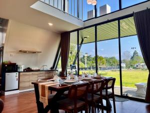 a kitchen with a table with chairs and a large window at ฟูจิจันท์ fujijun cafe&resort in Ban Na Khieo