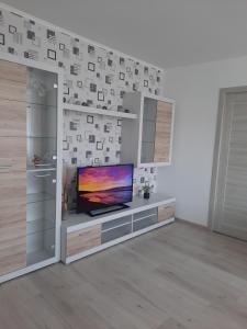 a living room with a flat screen tv on a entertainment center at PA Apartment in Rēzekne