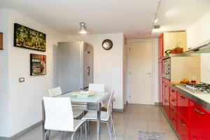 a kitchen with a table and white chairs at Villa Penelope in Terracina