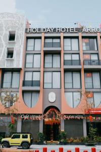 a hotel with a yellow truck parked in front of it at Holiday Hotel Van Don in Tài Xá