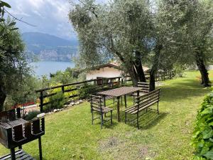 a picnic table and benches with a view of a lake at Etti's House in Malcesine +12 photos